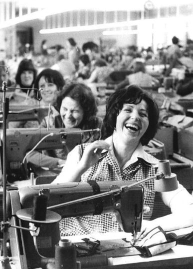 Workers laughing at a clothing factory