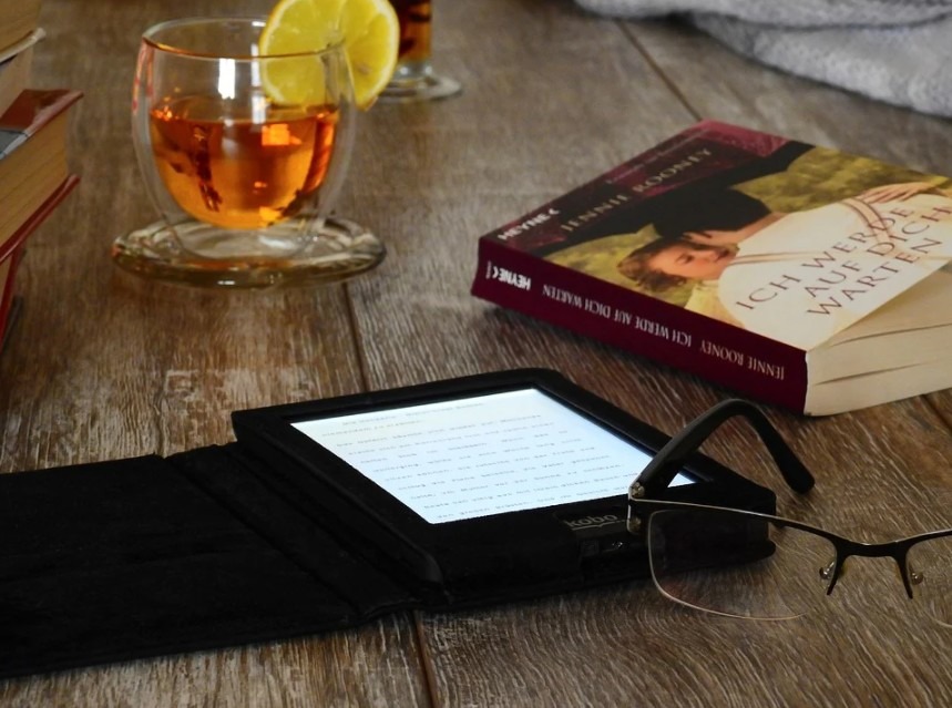an e-reader and a book on a table